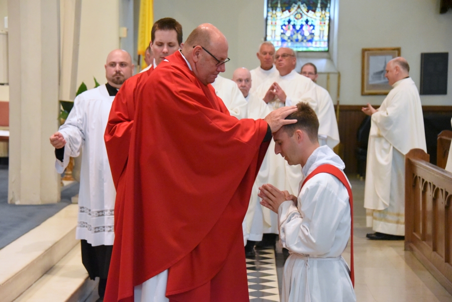 Father Wilfred Labbe lays hands on Deacon Matthew Valles.