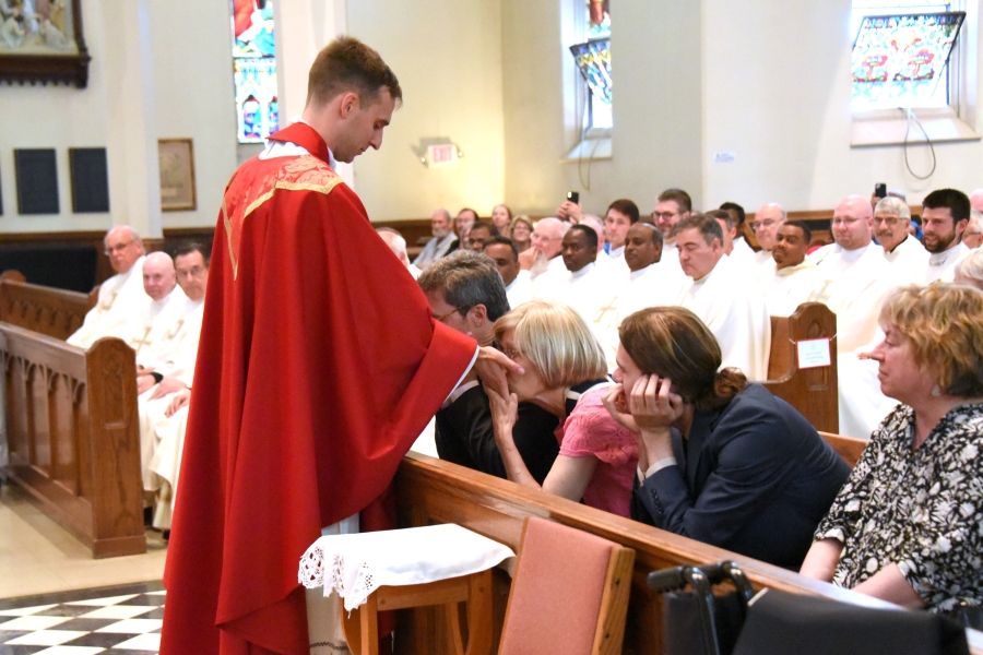 Father Matthew Valles blesses his parents who kiss his hands.