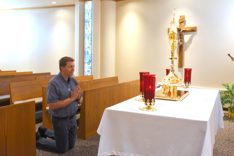 Brian Wilson kneels in eucharistic adoration.