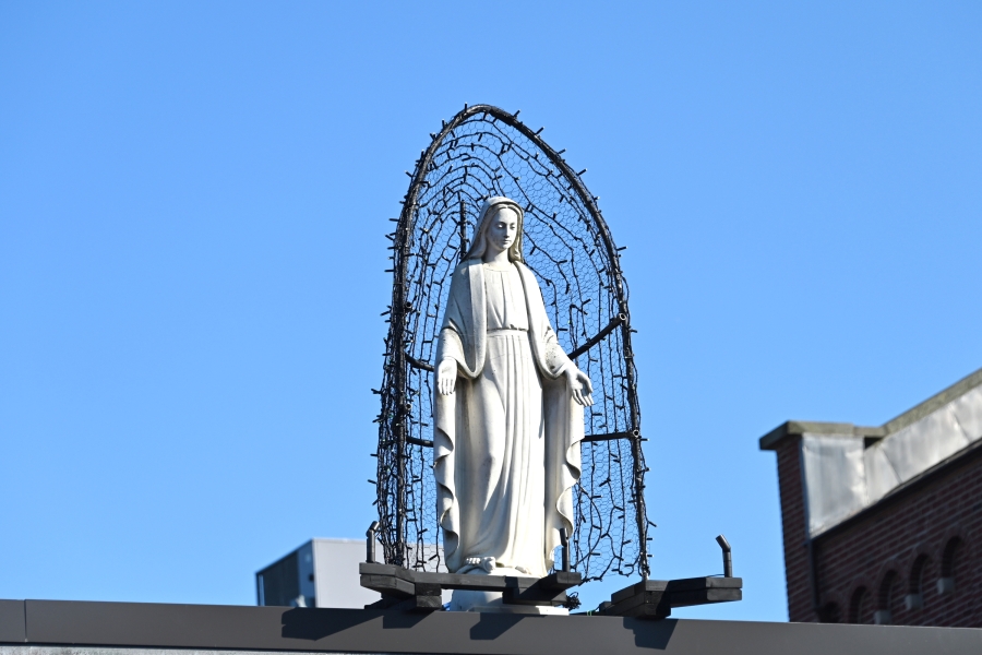 A statue of Mary on a rooftop.