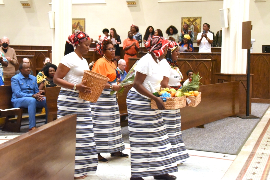 Women carry fruit during the offertory.