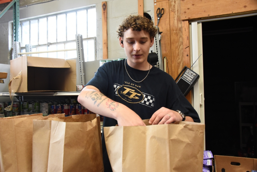 Volunteer puts food in a bag.
