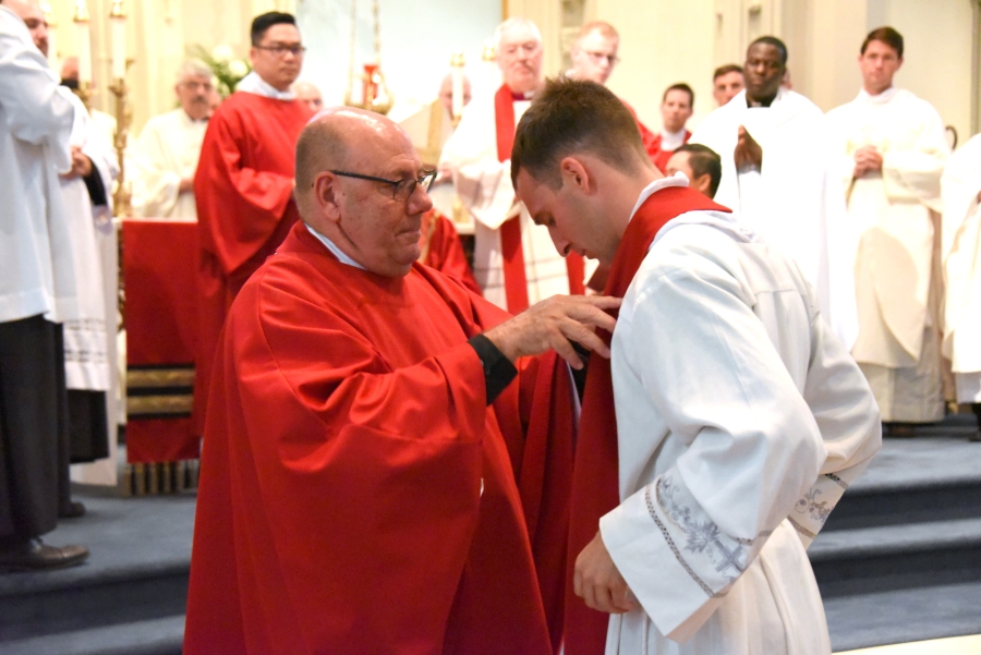 Father Wilfred Labbe vests Father Matthew Valles.