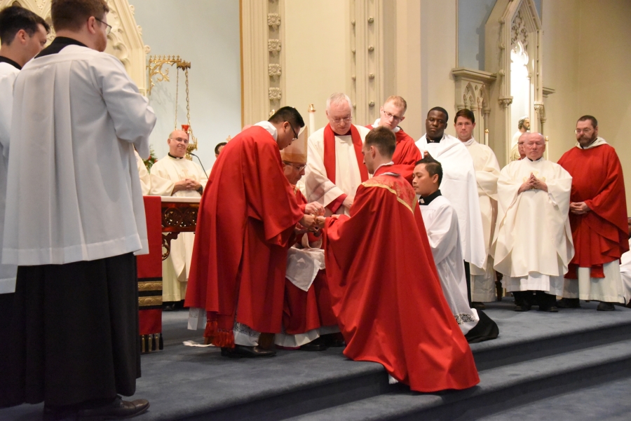 Bishop James Ruggieri anoints the hands of Father Matthew Valles.