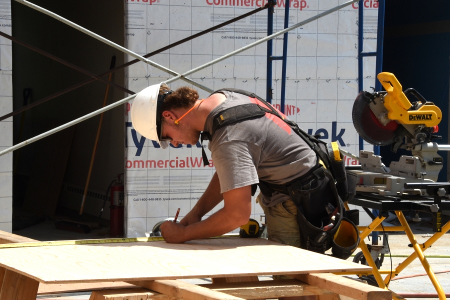 Worker saws a board