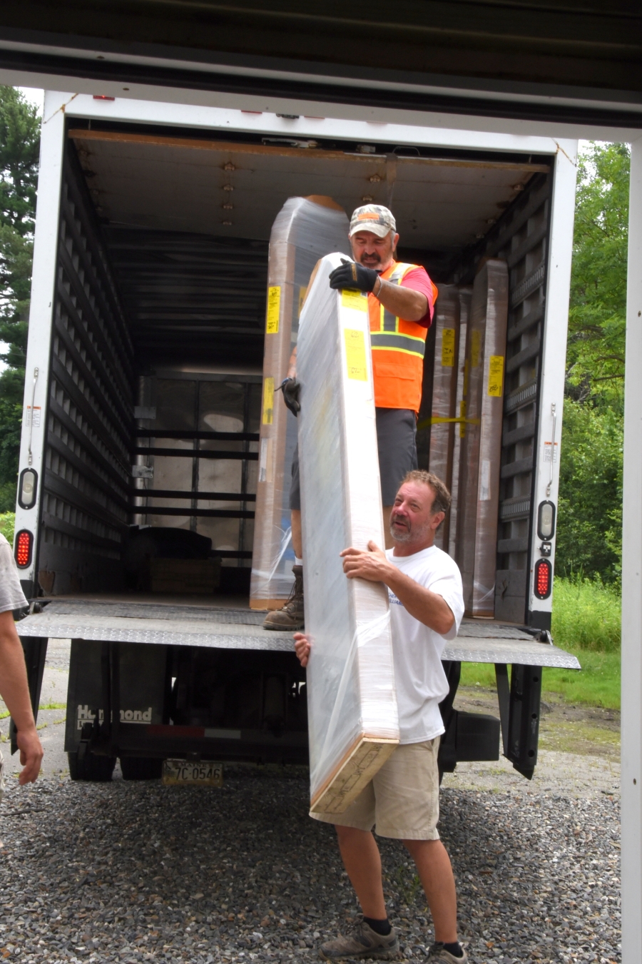 Rusty Harmon carries a window frame that is being unloaded from a truck.