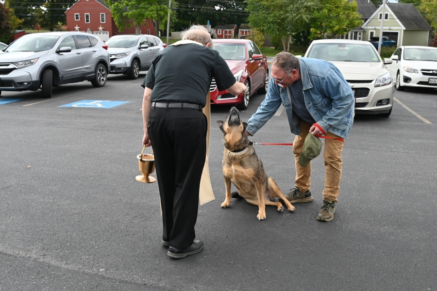 Father Michalowski blessing a dog.