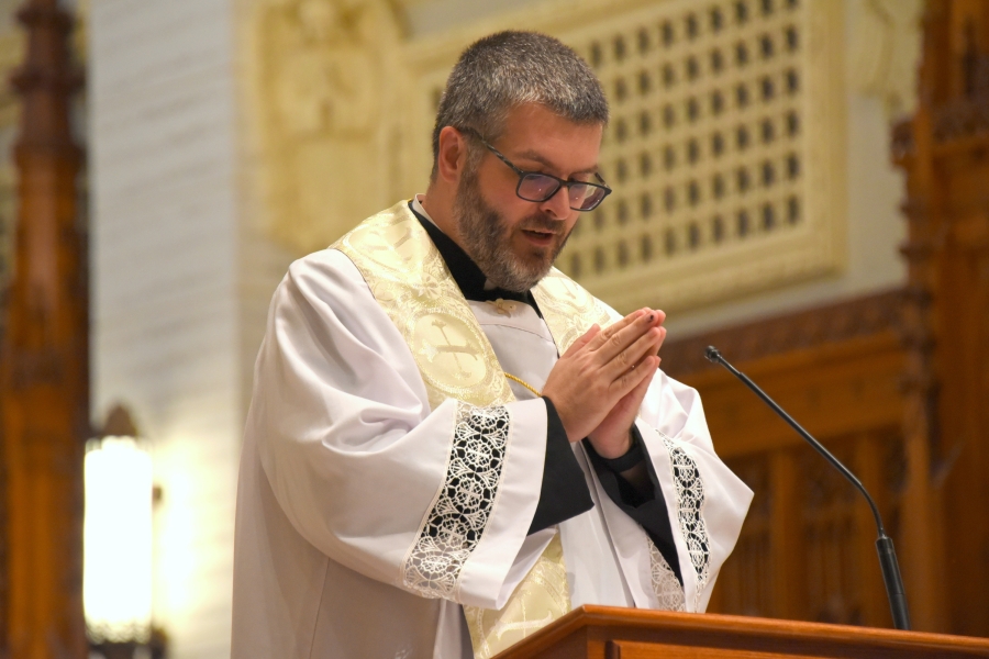 Father Patrick Finn reads a Gospel passage