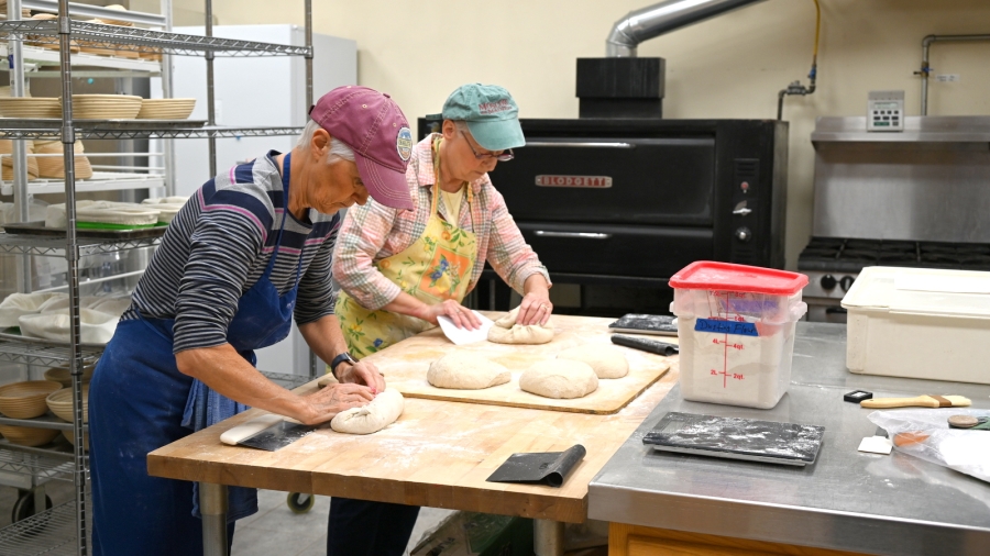 Anna Lake and Mariette Castonguay dividing the loaves