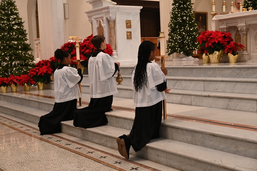 Altar servers kneel at the altar