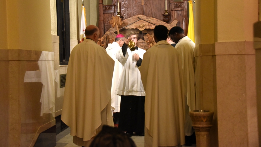 David Madore incenses priests and parishioners.