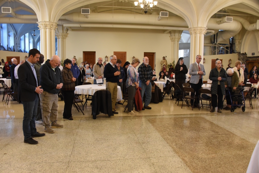 People pray at the reception for Brother Irenee Richard, OP