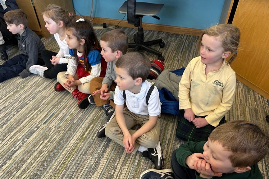 Students at St. John Catholic School sit in the hallway