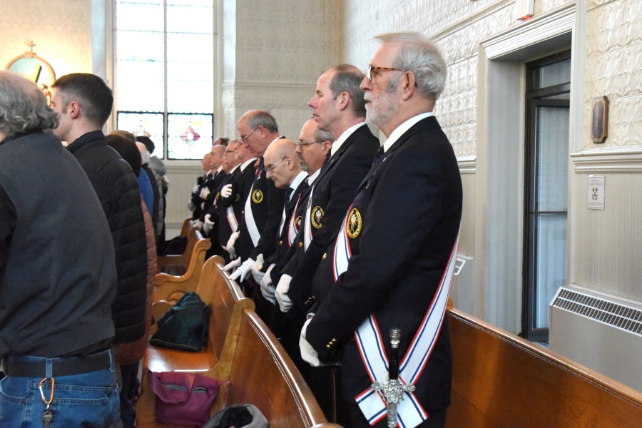 Knights of Columbus standing in back row of church.