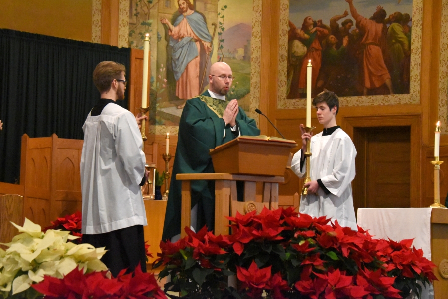 Father Kyle Doustou reads the Gospel.