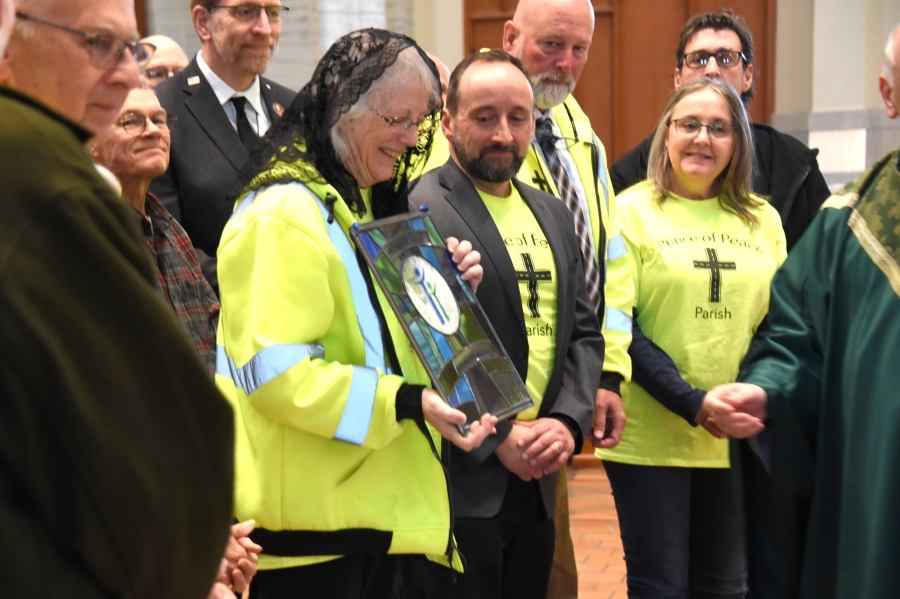 Denise Begin holding the Matthew 25 Award, surrounded by other volunteers.