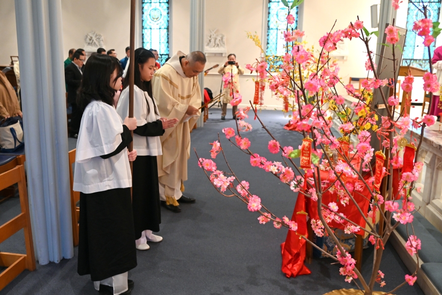 Father Dinh Votran bows before the ancestor altar.