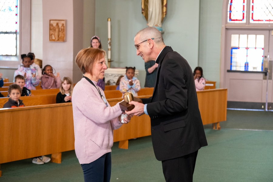 Ms. Ann Slonina accepts the award from Bishop Ruggieri