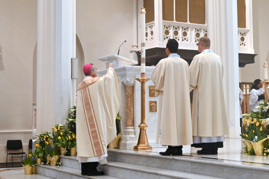 Bishop Ruggieri incenses the pastoral candle, along with Deacon Thanh Pham and Deacon Erin Donlon