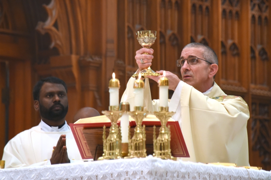 Bishop James Ruggieri raises the chalice during the Liturgy of the Eucharist.