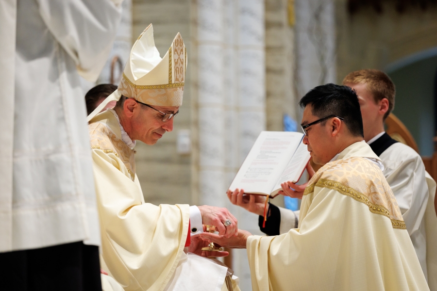 Bishop Ruggieri anoints the hands of Father Thanh Duc Pham.