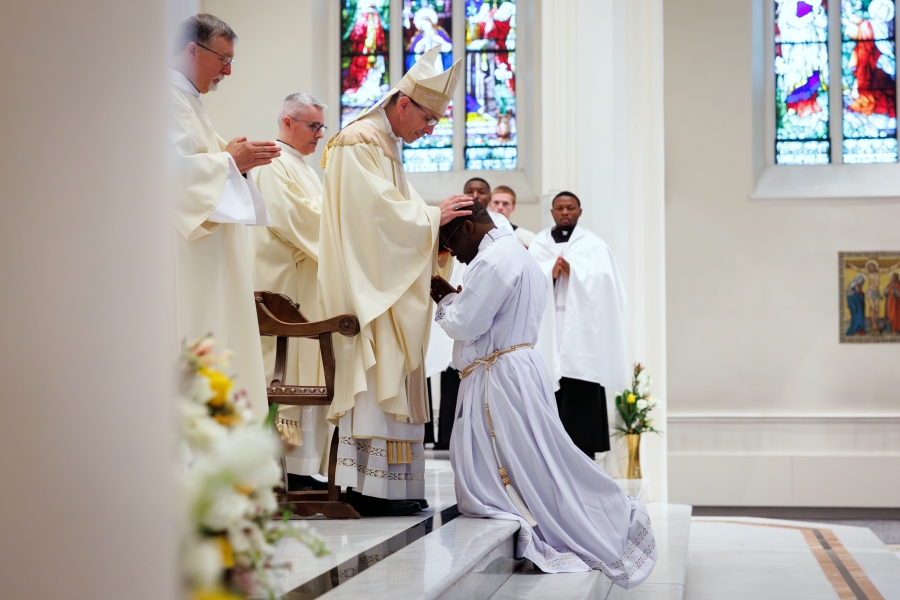 Bishop James Ruggieri lays hands on Ezekiel Yisi Banla.