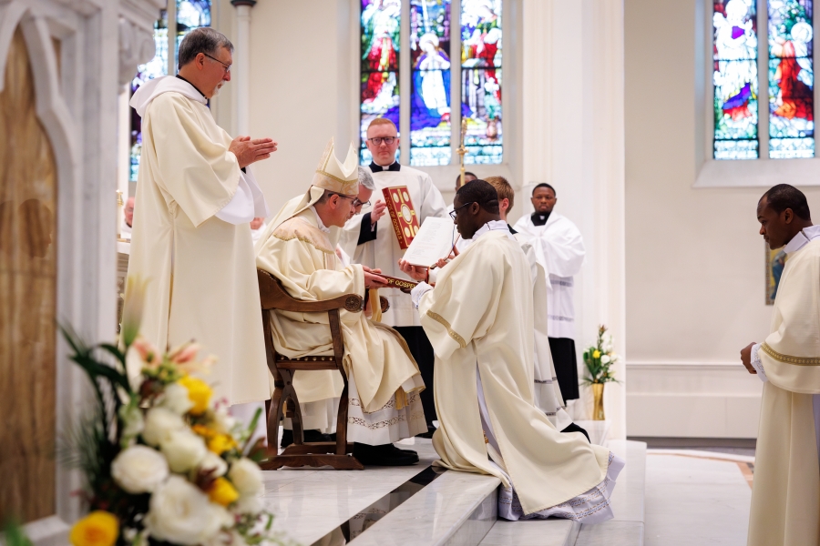 Bishop Ruggieri presents Deacon Yongyee with the Book of the gospels.