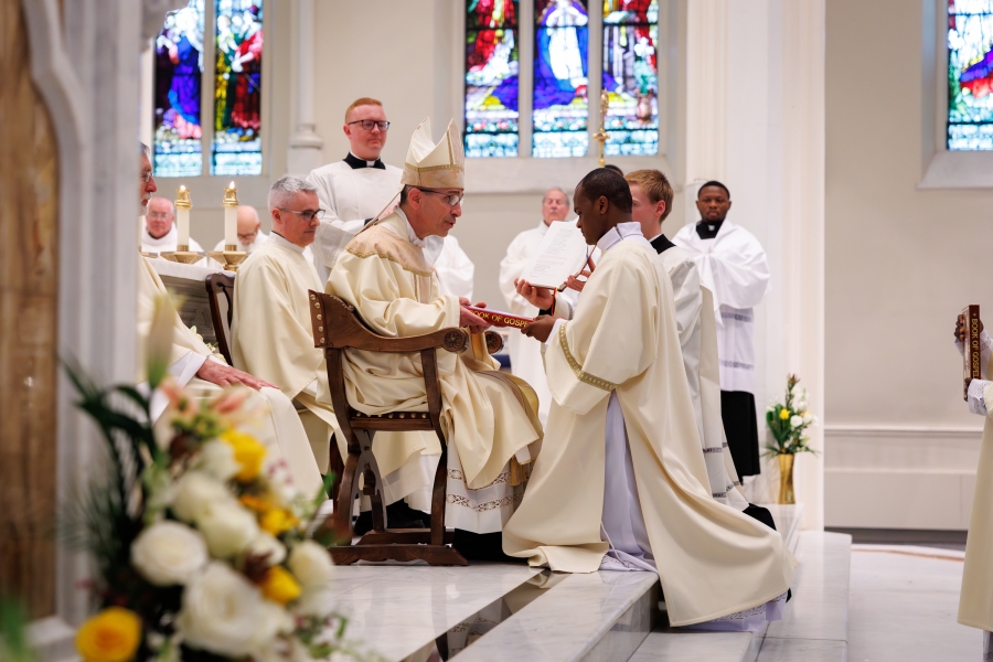 Bishop Ruggieri presents Deacon Banla with the Book of the Gospels.