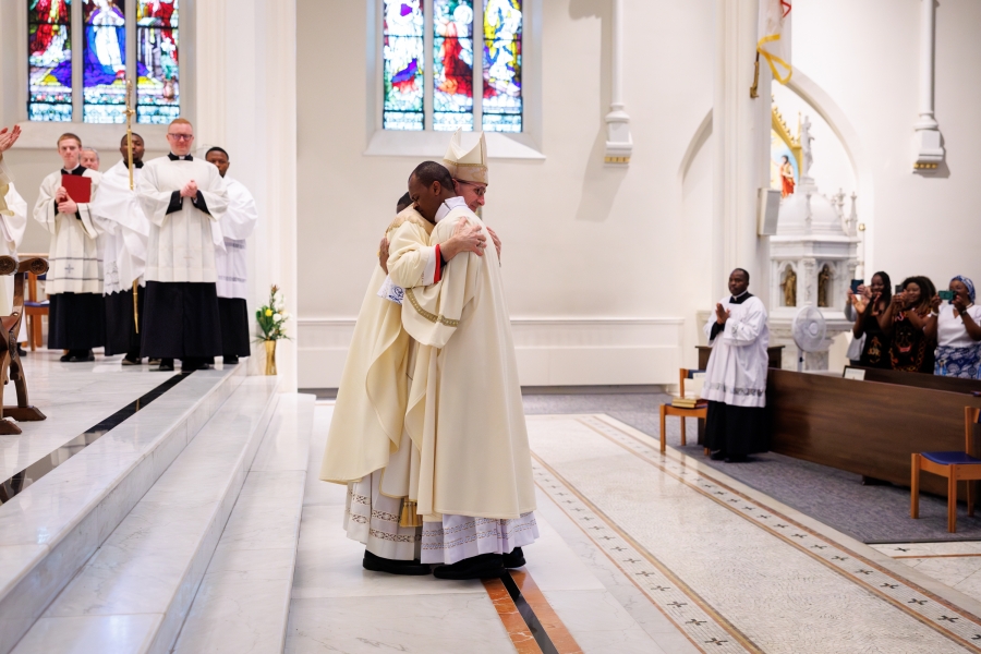 Bishop Ruggieri welcomes Deacon Banla with the fraternal kiss of peace.
