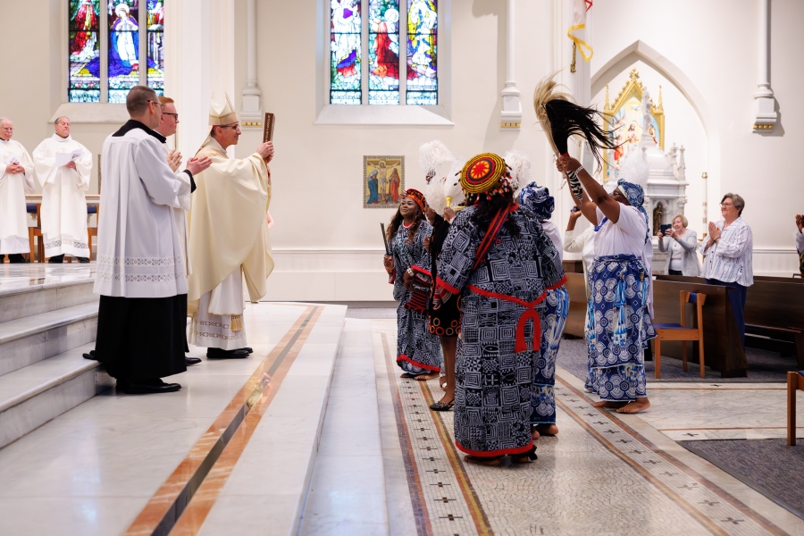 Dancers present the Book of the Gospels.