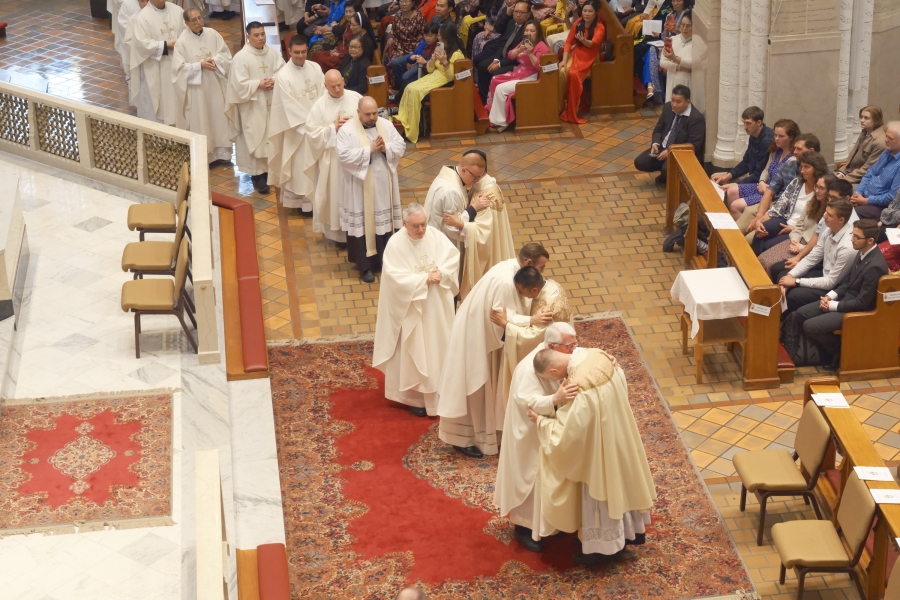 Priests line up to offer the Fraternal Kiss of Peace.
