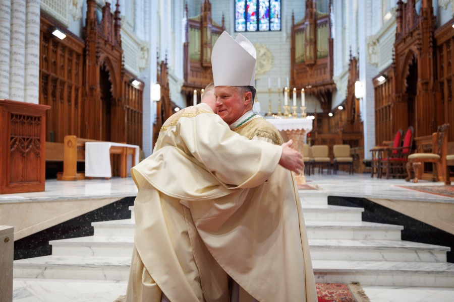Archbishop Broglio hugs Father Erin Donlon.