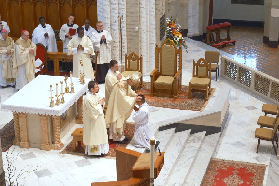 Priests line up to lay hands on the ordinands.