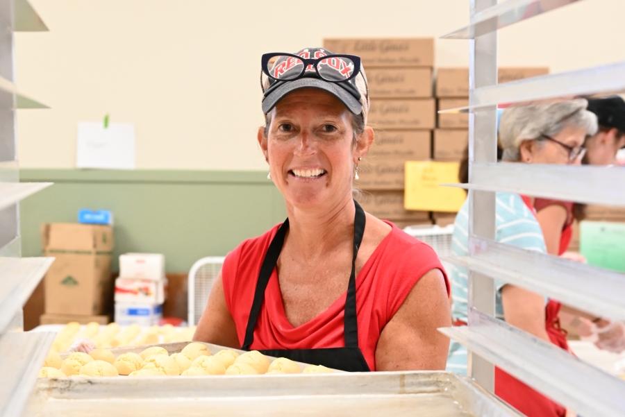 Woman carrying a tray of cookies.
