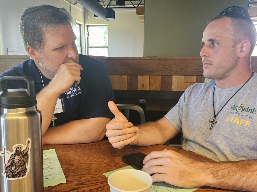 Two men speaking at a table