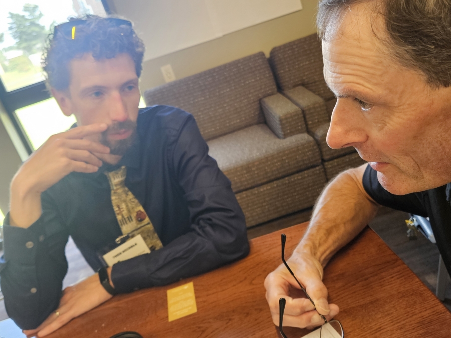 Two men speaking at a table