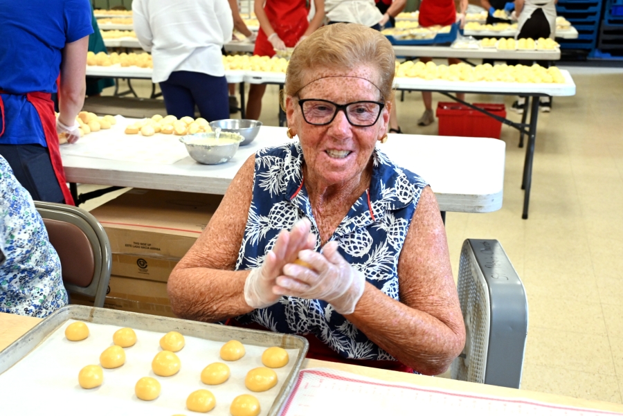 Woman rolling dough into a cookie ball.