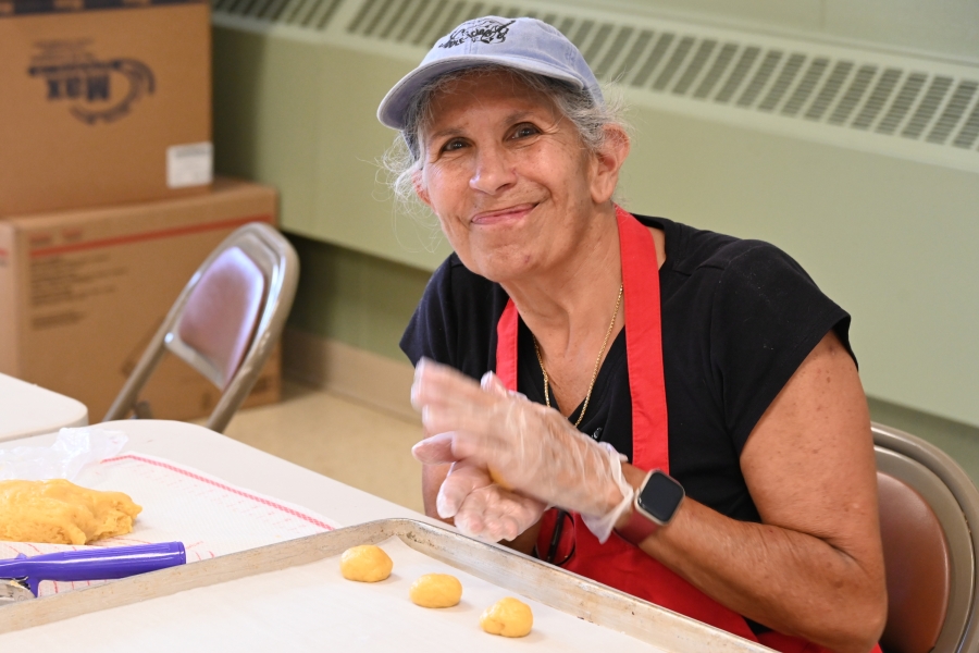 Woman rolling dough into cookie balls.