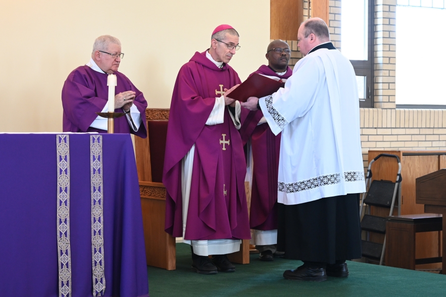 Bishop James Ruggieri, Deacon Jeffrey Lewis, and Peter Czerwinski, who is holding the book.