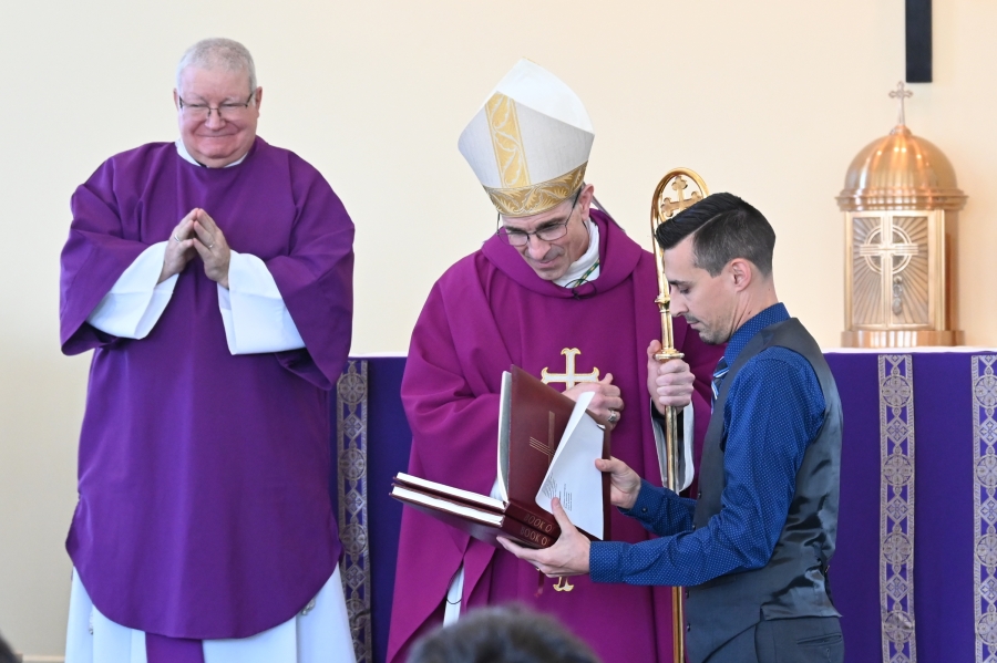 Bishop James Ruggieri examines a Book of the Elect.
