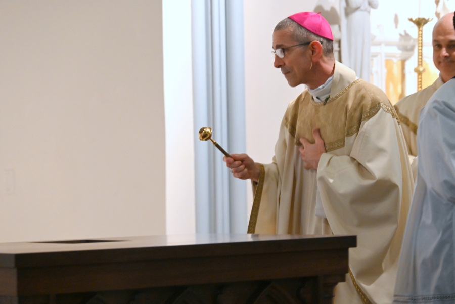 Bishop Ruggieri sprinkles holy water on the altar.