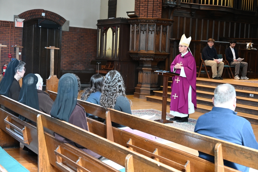 Bishop James Ruggieri delivers his homily. Front rows of the pews are also visible.