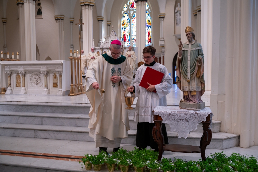 Bishop Ruggieri blesses the shamrocks with Holy water