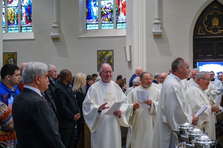 Priests enter Chrism Mass