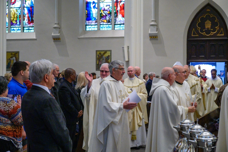 Priests enter Chrism Mass