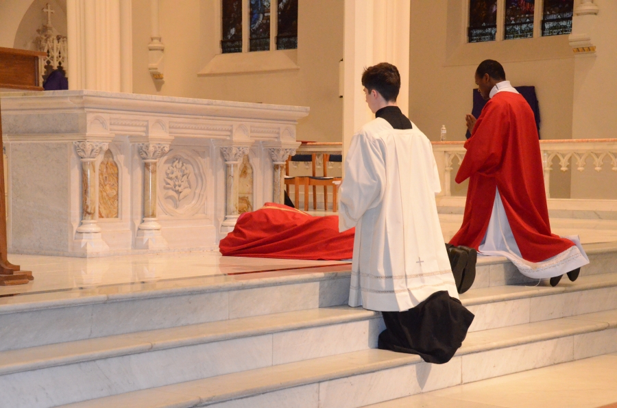 Bishop laying prostrate at the altar