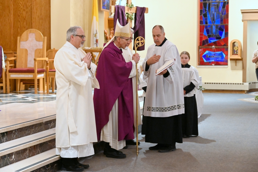 Bishop James Ruggieri stands before priests asking them to renew their vows.