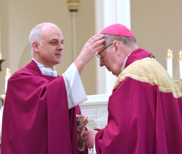 Father Seamus Griesbach marks the forehead of Bishop Robert Deeley with ashes.