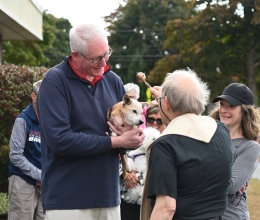 Father Michalowski sprinkles a dog with holy water.