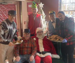 Group surrounding a Santa Claus seated